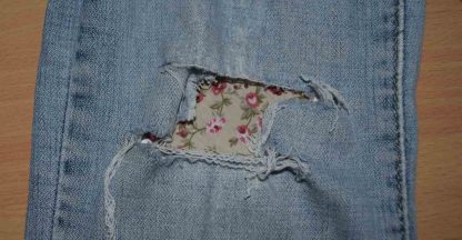 Vintage-Patch Jeans Reverse Repair Undercover Patch Fawn Trailing Rose on faded denim jeans