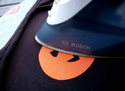 orange pumpkin face motif being ironed on to black camisole vest top